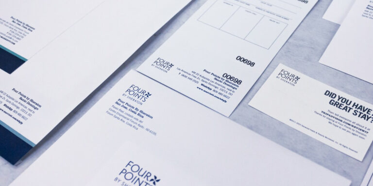 Imagen de papelería corporativa impresa para Four Points by Sheraton, con formatos de facturas, sobres y tarjetas en diseño minimalista blanco con tipografía azul, representando impresión hotelera profesional en Cancún.