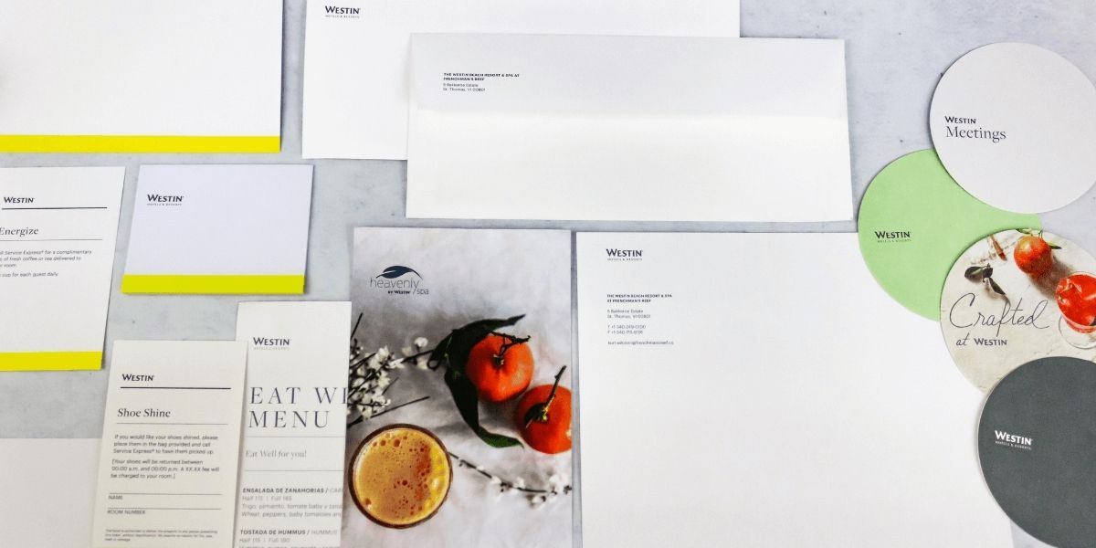 Imagen de papelería corporativa de Westin Hotels impresa en Cancún, con sobres, menús, folletos y posavasos en tonos blancos, verdes y amarillos, destacando diseño elegante y branding hotelero premium.