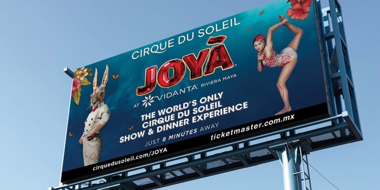 Espectacular publicitario impreso por Grupo Regio para Cirque du Soleil JOYÀ en Vidanta Riviera Maya, con fondo azul, tipografía roja brillante y personajes artísticos, promoviendo la experiencia única de show & dinner.
