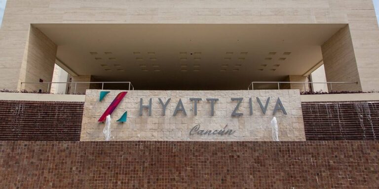 Letrero corporativo en letras metálicas instalado por Sign Factory en la fachada del hotel Hyatt Ziva Cancún, sobre muro de piedra con fuentes decorativas, transmitiendo elegancia y prestigio en señalética exterior.