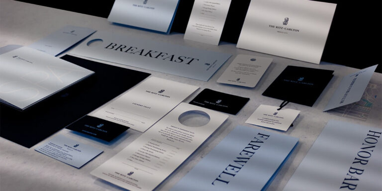 Imagen de papelería corporativa para The Ritz-Carlton, con menús, colgantes de puerta, tarjetas y folletos en diseño minimalista blanco y negro, ejemplo de impresión hotelera premium y acabados de lujo realizada en Cancún por Grupo Regio.