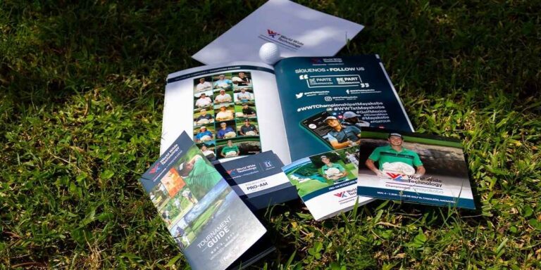 Imagen de material impreso para el torneo de golf World Wide Technology Championship en Mayakoba, con folletos y revistas de alta calidad sobre césped verde, ejemplo de impresión profesional en Cancún por Grupo Regio.