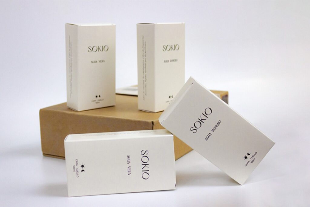 Cajas blancas de cosméticos Sokio con tipografía elegante, impresas por Grupo Regio para presentación premium.