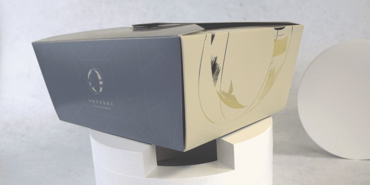 Packaging de lujo Orfebre, diseño sofisticado con acabados metálicos y branding elegante para productos exclusivos.