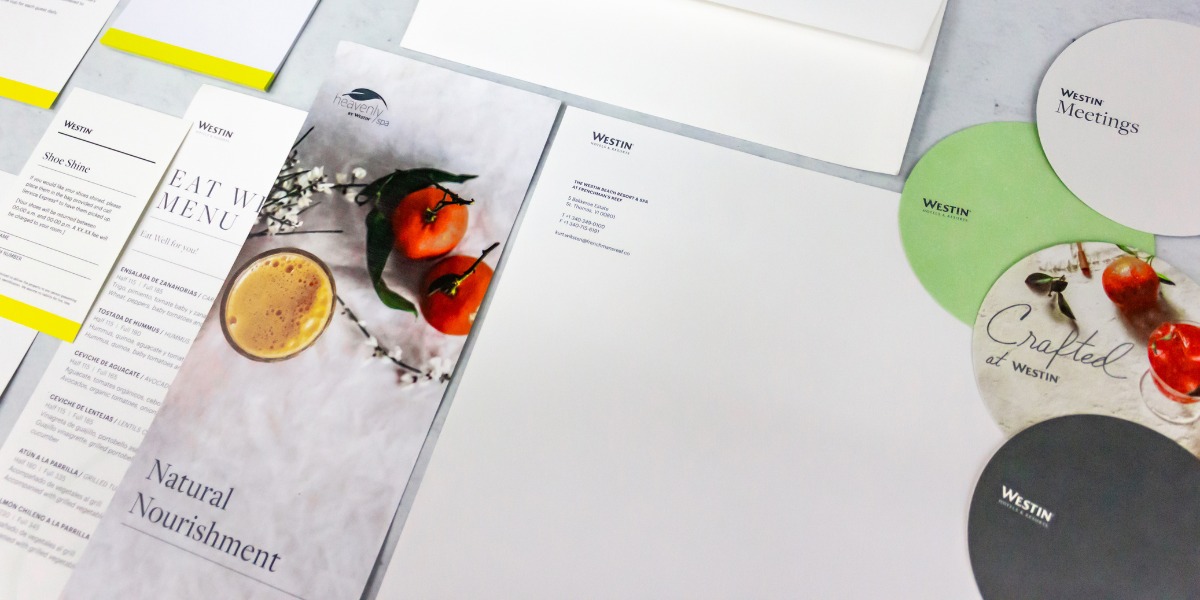 Imagen de papelería corporativa para Westin Hotels & Resorts, con menús gastronómicos, hojas membretadas y portavasos circulares en tonos blanco, verde y gris, ejemplo de impresión hotelera premium y diseño elegante realizada en Cancún por Grupo Regio.