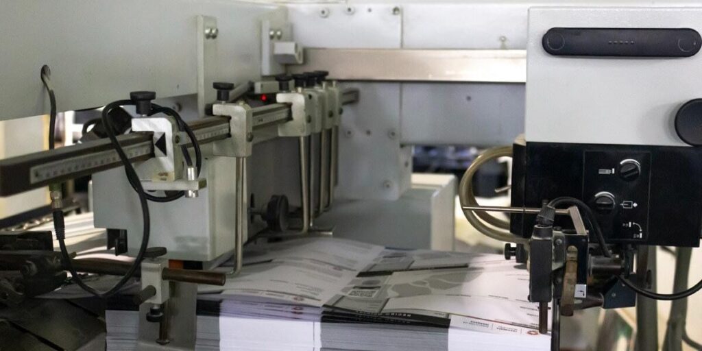 Máquina de impresión industrial de Grupo Regio procesando hojas a alta velocidad para materiales gráficos en Cancún.