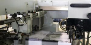 Máquina de impresión industrial de Grupo Regio procesando hojas a alta velocidad para materiales gráficos en Cancún.