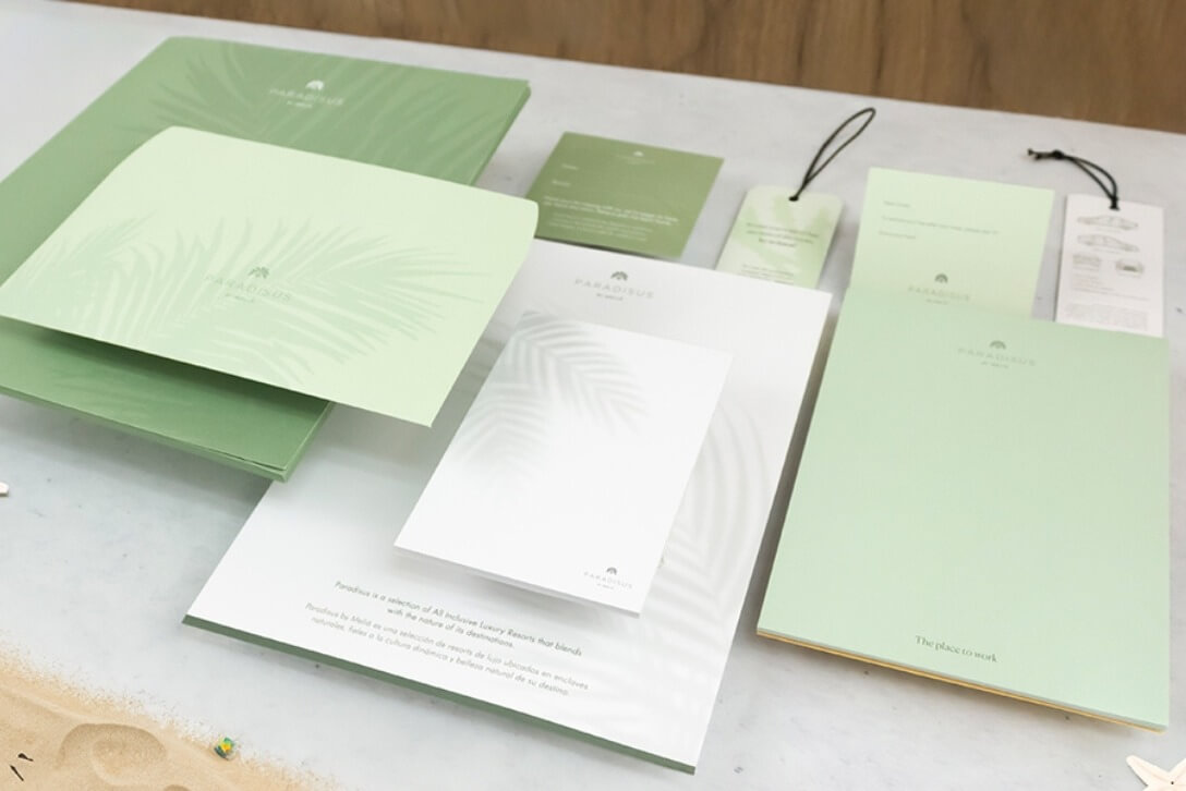Papelería institucional en tonos verdes y blancos con logotipo Paradisus, impresa por Grupo Regio en Cancún.