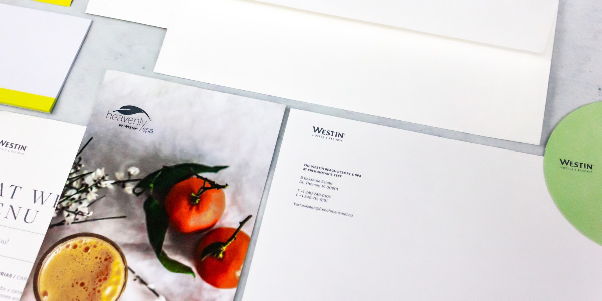 Imagen de papelería corporativa para Westin Hotels & Resorts, con menú gastronómico ilustrado con tomates y bebida, hojas membretadas y portavasos verdes, ejemplo de impresión hotelera premium en Cancún realizada por Grupo Regio.