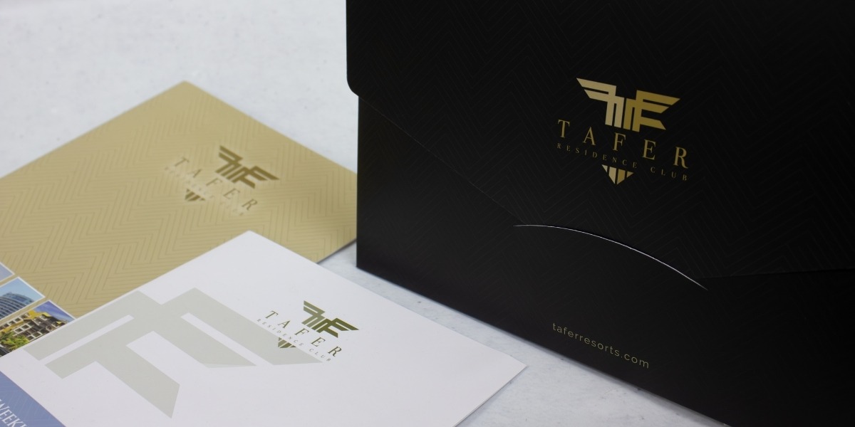 Carpeta y folletería premium de Tafer Residence Club impresos por Grupo Regio, con acabados elegantes en negro y dorado que refuerzan el prestigio de la marca.