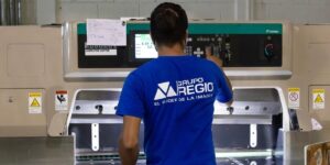 Operador de Grupo Regio maneja cortadora digital Itotec para impresión y acabados de alta calidad en Cancún.