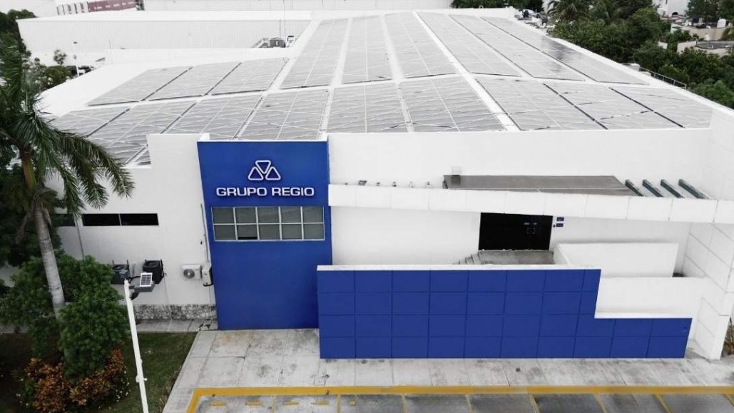 Fachada de Grupo Regio en Cancún con paneles solares y planta de impresión sustentable.
